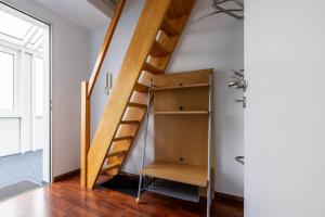 a wooden staircase in a room with a shelf at Exklusive Ferienwohnung am Südstrand mit Panoramabalkon & Meerblick Wohnung 92 in Wilhelmshaven