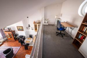an attic office with a desk and a table at Exklusive Ferienwohnung am Südstrand mit Panoramabalkon & Meerblick Wohnung 92 in Wilhelmshaven +13 photos