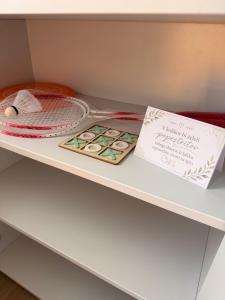 a shelf with a tennis racket and a sign on it at Panonska hiška - Panonian nest - vključeni 2 kopalni karti za Terme3000 in Moravske-Toplice