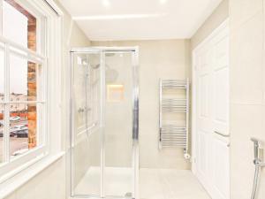 a glass shower in a bathroom with a window at NEW Artisan Apartment by Signature Stays - Modern - Spacious - Parking in Cheltenham