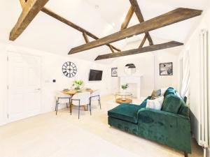 a living room with a green couch and a table at NEW Artisan Apartment by Signature Stays - Modern - Spacious - Parking in Cheltenham