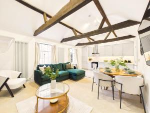 a living room with a green couch and a table at NEW Artisan Apartment by Signature Stays - Modern - Spacious - Parking in Cheltenham +26 photos