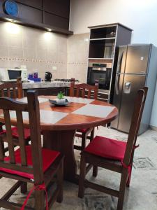 a kitchen with a wooden table with chairs and a refrigerator at Yahweh temporarios in Río Grande +6 photos