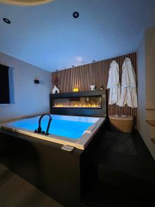 a bathroom with a hot tub with a fireplace at Maison Nina, Suite d’exception in LʼÎle-Saint-Denis