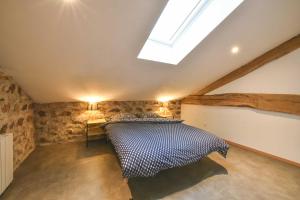 a bedroom with a bed in a room with a skylight at Gîte à La Ferme de l'Oasis in Saint-Marcel-de-Félines