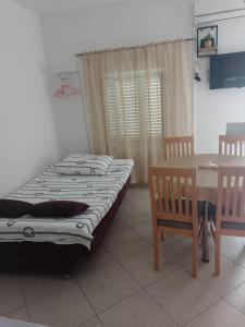 a bedroom with two beds and a table and chairs at Apartman Cvitan in Zaton