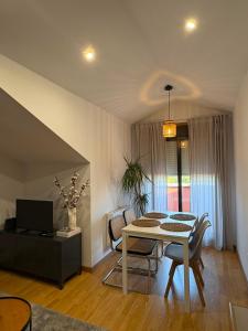 a living room with a dining room table and chairs at O Ático in Rosal +9 photos