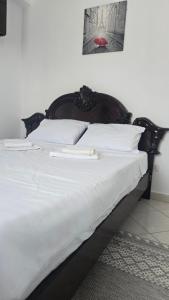 a large white bed with white sheets and a red lips at Maritimo Apartment in Constanţa