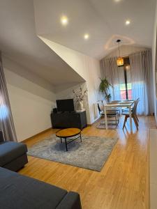 a living room with a table and a couch at O Ático in Rosal