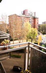 un balcone con due piante in vaso e vista sulla città di SanSi a Milano