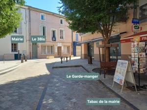 a street with buildings and a sign on a sidewalk at Le 3Bis studio charmant proche Cap d'Agde in Bessan