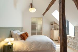 a bedroom with a bed with white sheets and pillows at La Papote in Bourron-Marlotte