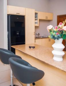 a kitchen with a counter with a vase of flowers at Home Very Close To CBD in Gaborone