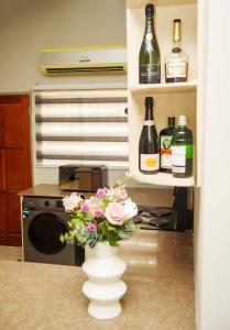 a vase with flowers in a kitchen with wine bottles at Home Very Close To CBD in Gaborone