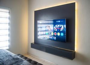 a flat screen tv on a wall in a room at Home Very Close To CBD in Gaborone