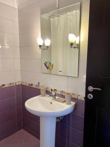 a bathroom with a white sink and a mirror at Dhimitri Rooms in Gjilek
