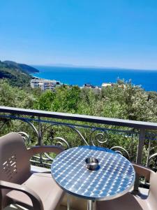 a blue table and chairs on a balcony with the ocean at Dhimitri Rooms in Gjilek