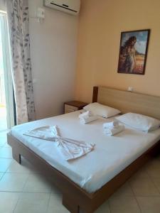 a bedroom with a bed with two towels on it at Dhimitri Rooms in Gjilek +2 photos