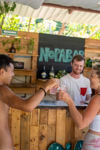 a woman handing a man a drink at a bar at Nopalero Hostel in Puerto Escondido