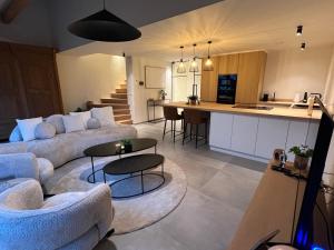 a living room with a couch and a kitchen at Hartje Borgloon in Borgloon