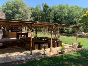a wooden pavilion with a picnic table in a park at Meerkat Manor in Coddington