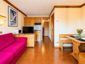 a living room with a red couch and a kitchen at Hostdomus - A3-07 in Grange Sises