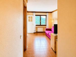 a living room with a purple couch and a window at Hostdomus - A3-07 in Grange Sises