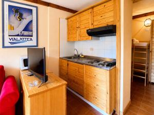 a small kitchen with a stove and a tv at Hostdomus - A3-07 in Grange Sises +4 photos