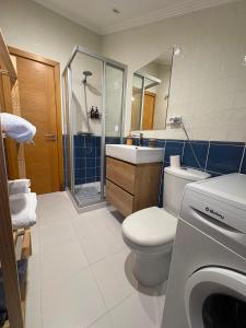 a bathroom with a toilet and a sink and a shower at O Ático in Rosal