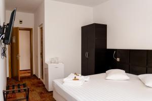 a bedroom with two beds and a black cabinet at Hotel Mercur in Eforie Sud