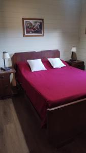 a large red bed with two white pillows on it at La Soñada in San Javier