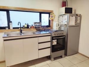 a kitchen with a stainless steel refrigerator and a sink at Casa Giovanna in Puerto Natales