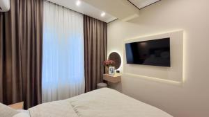 a hotel room with a bed and a television at Rent&live beautiful apartment in Chişinău