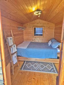 a bedroom in a log cabin with a bed and a ladder at Camp The sunrise hill in Pivka