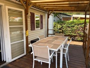 a wooden table and chairs on a deck at Mobil-home proche plage in Saint-Julien-en-Born