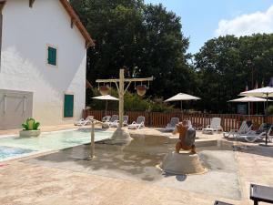 a swimming pool with a cross and chairs and a church at Mobil-home proche plage in Saint-Julien-en-Born