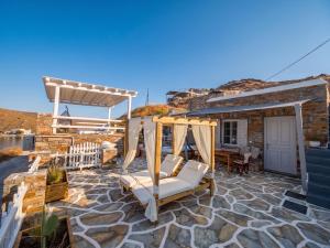 a patio with a swing and a house at KL , Cozy Suite II in Kithnos
