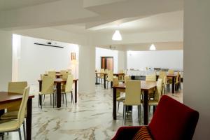 a dining room with wooden tables and chairs at Hotel Mercur in Eforie Sud