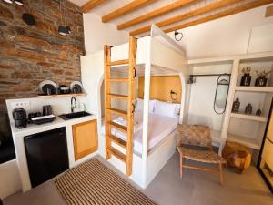 a small bedroom with a bunk bed and a kitchen at KL , Cozy Suite II in Kithnos