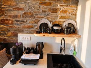 a kitchen counter with a sink and a stone wall at KL , Cozy Suite II in Kithnos