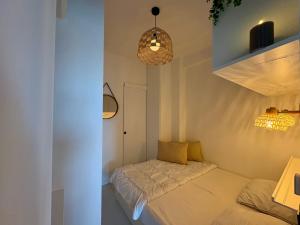 a small bedroom with a bed and a pendant light at SEA VIEW Juweeltje in Knokke-Heist