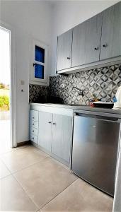 a kitchen with white cabinets and stainless steel appliances at Fragos Apartments in Santa Maria +59 photos