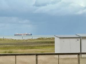 a building on the beach with a large object in the water at SEA VIEW Juweeltje in Knokke-Heist +43 photos