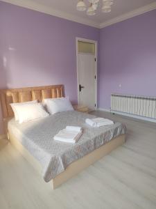 a bedroom with a bed with two towels on it at Bright Modern Suite in Quba +7 photos