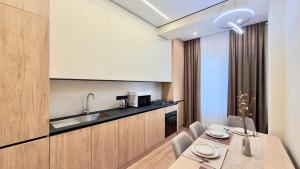 a kitchen and dining room with a table and chairs at Rent&live beautiful apartment in Chişinău