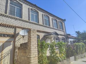 a brick building with ivy on the side of it at Bright Modern Suite in Quba