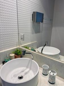 a white bathroom with a sink and a mirror at Mini Casa-Aconchego e Fitness in Pirenópolis +9 photos
