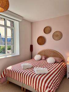 a bedroom with a bed with a red and white striped blanket at Le Presbytère in Ambleteuse