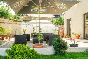 a patio with chairs and an umbrella and plants at Hotel Mercur in Eforie Sud
