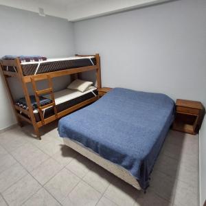 a bedroom with a bunk bed with a blue blanket at Ayinmai in Trelew